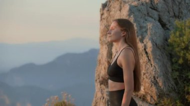 Antrenman öncesi hareketler. Genç bayan koç dağda duruyor ve blog için egzersiz videosu kaydetmeye hazırlanıyor. Çevrimiçi Fitness blogcusu eğitiyorum. Blogger Kavramları. Sinematik 4k görüntü