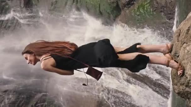 Жінка Довга Чорна Сукня Стоїть Скелі Біля Водоспаду Молода Дівчина — стокове відео