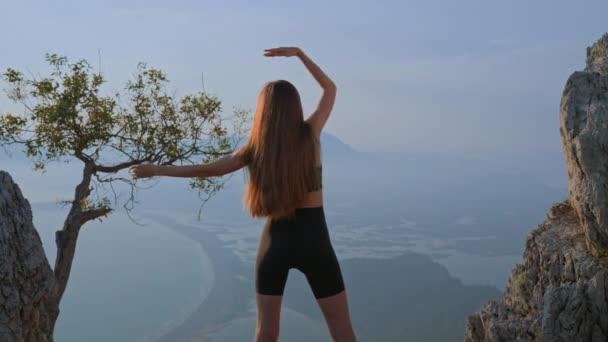 운동을 여자가 운동을 뒷모습 연습을 소녀는 섬들의 아름다운 경치를 중턱에서 — 비디오