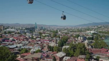 Teleferikli eski ve modern şehrin güzel bir manzarası. Başla. Binaların üzerinden geçen teleferikli güzel bir manzara. Tiflis. Yüksek kalite 4k görüntü