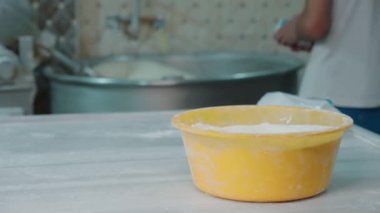Odağı ön plandan arka plana kaydırıyorum. Baker bir maya paketini alır ve büyük bir miksere ekler. Ekmek yapma, küçük işletme, gerçek insanlar. Gerçek bir pastanede Tahsilat Günü