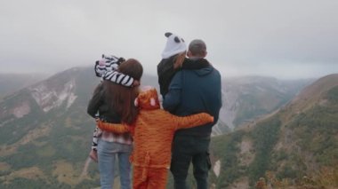 Aile tatilleri. Hayvan kostümü giymiş çocuklar ailelerine sarılıyorlar. Birlikte iyi vakit geçirin. Dağ Oteli. Aile gezisi. Yolculuk. SLO MO 4k.