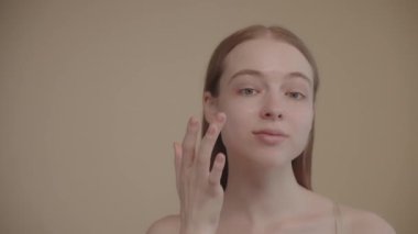 Portrait young woman uses creams of her face. Concept fresh moisturized skin beautiful closeup cosmetic face happy healthy model. Young blonde hair woman take care of her skin. Slow motion 4k footage