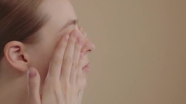 Woman washes face with organic foaming soap, closeup view from the side. Girl cleanses facial skin, enjoying making massage movements. Beauty Wellness Healthy skin care treatment concept, SLO MO 4K
