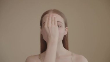 Young girl holds cotton pad while cleansing face with cleansing toner. Skin care removal of makeup cleansing with lotion or micellar water. Basic facial skin care. 4k footage SLO MO