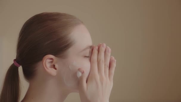 Νεαρή Γυναίκα Χρησιμοποιεί Αφρό Καθαρισμού Για Πλύνει Πρόσωπό Της Διαδικασία — Αρχείο Βίντεο