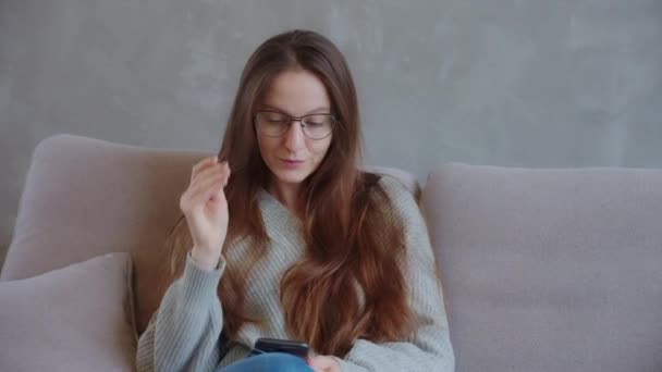 Gülümseyen Genç Bayan Müşteri Elinde Gözlük Akıllı Telefon Ile Evdeki — Stok video