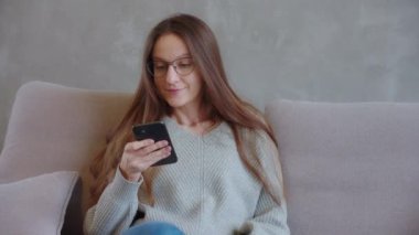 30 'lu yaşlardaki genç bir kadın rüya gibi bir alışveriş yaptı. Tatmin olmuş bir kadın ödeme yaptıktan sonra bir anlık mutluluğun tadını çıkarır. Ödeme platformları, başvurular, online bankacılık, e-ticaret kavramları. SLO MO