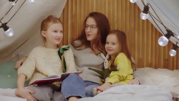 Mom Two Daughters Sitting Bed Bedroom Reading Book Having Fun — Stock Video