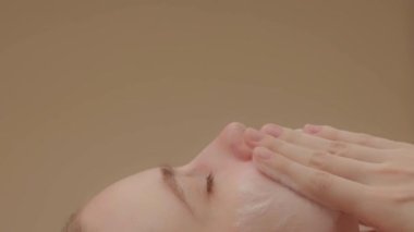 Woman washes face with organic foaming soap, closeup view from the side. Girl cleanses facial skin, enjoying making massage movements. Beauty Wellness Healthy skin care treatment concept, SLO MO