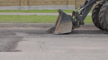 Yeni yüzey kaldırımlarının döşenmesi için hazırlık. Makine yol yüzeyini kumdan ve küçük taşlardan temizler. Çukur tamir yüzeyi. Otoyol bakımı. Otoyolun yeniden uygulanması.