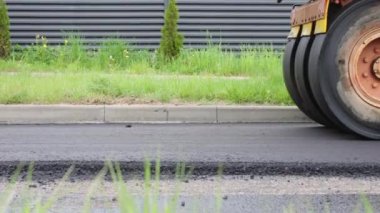 Yolun yüzeyini onarmak, şehir sokaklarına yeni bir asfalt döşemek. Asfalt döşeme işlemi bir kaldırım makinesiyle.