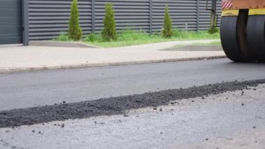 Yol tamiri. Asfalt döşeme. Tekerlek yeni bırakılmış asfaltı düzleştiriyor. Şehir sokaklarında asfalt döşeme işlemi..