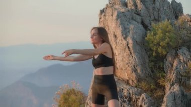 Kendine güveni tam mutlu genç atletik bir kadın gün doğumunda, güne ısınmayla başlıyor, sabah egzersizleri yapıyor, sağlıklı yaşam tarzı kavramı. Fitness dışarıda. Yavaş çekim