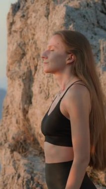 Genç, çekici, kendine güvenen bir kadın esintiden sonra ılık bir esintinin tadını çıkarıyor. Kendinle baş başa vakit geçir. Sağlıklı yaşam, refah ve farkındalık kavramı. Dikey Video