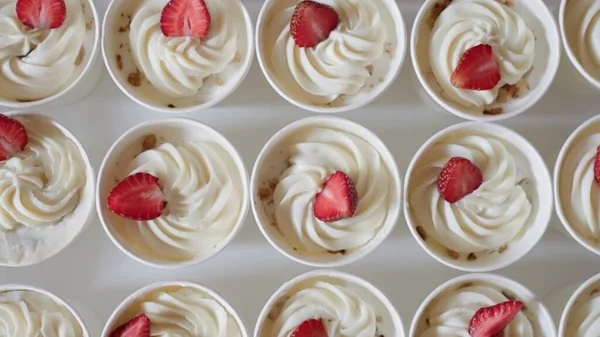 Dessert cups, whipped cream of alternative milk, strawberries, nut pieces. Commercial for desserts deliciously beautiful food Confectionery
