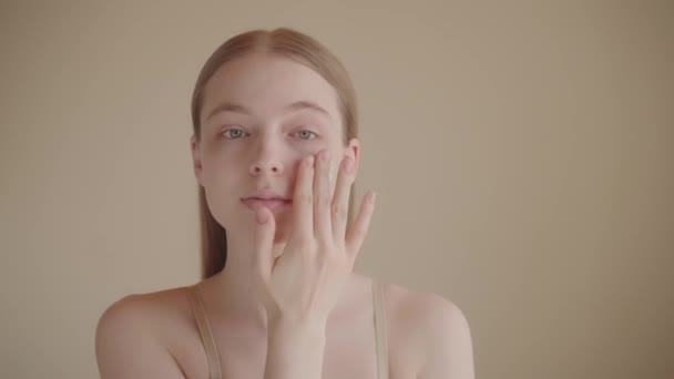 クローズアップ財団を申請する美しい白人女性 魅力的な若い女性のカメラを見て 孤立した背景 スタジオショット 朝の化粧ルーチン スキンケア広告 — ストック動画