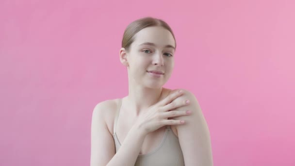 完璧な肌を持つ若いブロンドの女性のクローズアップ美の肖像画 ライトピンクの背景にカメラを見ている美しさのモデル スキンケア製品の成果コンセプト スキンケアトリートメント — ストック動画