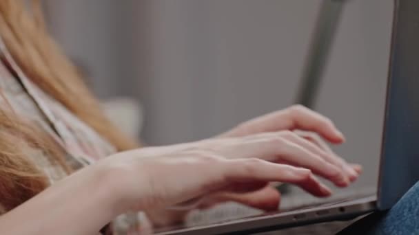 サイドビュー ラップトップと座っている若い女性 ノートパソコンのキーボード チャットボットのクエリ ウェブサーフィン Eラーニング 検索クエリ ソーシャルネットワーキングにタイプする認識できない女性の手を閉じます — ストック動画