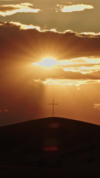 复活节 耶稣基督的复活 基督教信仰的象征 在阳光下在山上交叉 交叉口的电影轮廓 太阳光的镜片中闪烁着光芒 垂直录像 — 图库视频影像