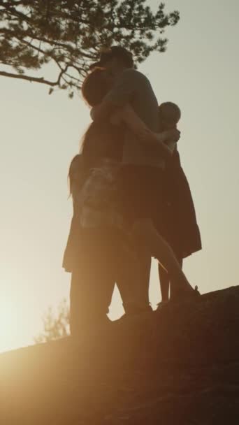 シルエットハッピーファミリー 子供と抱擁する両親 公園で散歩 夕日ピクニック 友好的な家族として一緒に時間を過ごす 幸せな子供時代の思い出 娘と妻を愛する父親 — ストック動画