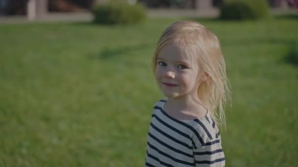 따라와요 재미있는 금발의 소녀는 그녀를 카메라를보고 개념을 잔디에 화창한 귀여운 — 비디오