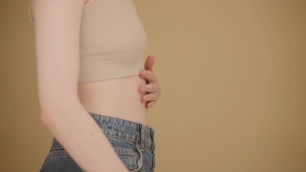 胃の痛み 胃炎の症状 腸の消化不良および祝福に苦しんでいる病気の若い女性 重要な日 健康の概念 少女はベージュの背景に立っている — ストック動画
