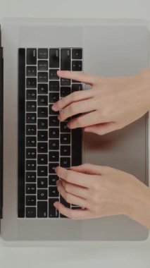 Dikey video Üst Görünüm tablosu Chatbot AI komut mühendisliği programlamasını çalıştıran Yapay zeka araçları kullanan bir klavye dizüstü bilgisayarı üzerinde yazan kadın elleri