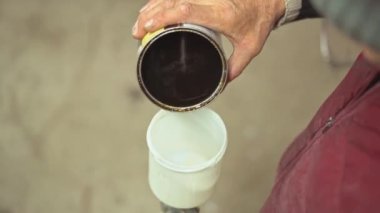 Bir marangozun çalışan ellerinde bir boya fırçası. Mobilya boyamak için hazırlık. Çalışan eller. Mobilya yenileme atölyesi. Sıkı çalışma, kusurlu çalışma, el işi, işçi sınıfı. Çalışan adam