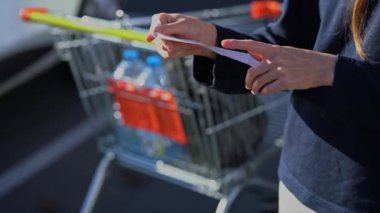 Alıcı çekleri. Müşteri makbuzu. Arka planda alışveriş arabası var. Süpermarketin kağıt makbuzu. Toplam pahalı. Yazar kasa. Hypermarket 'e para harcamak. Aile bütçesi. Fatura kontrol.