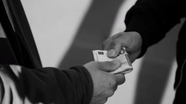 Avro banknotlarından bir rüşvet. Erkek ellerinin parayı teslim ettiği yakın plan, siyah beyaz görüntü. Yolsuzluk, dolandırıcılık, para aklama, uyuşturucu satışı. Belgesel tarzı Görüntü
