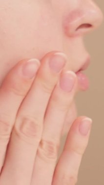 Yüzüne serum süren genç bir kadının yakın planda görüntüsü çekiliyor. Sabah güzellik rutini. Yüzüne damlatıcıyla yüz serumu süren genç bir kız. Kozmetik ürünlerin reklamını kavra.