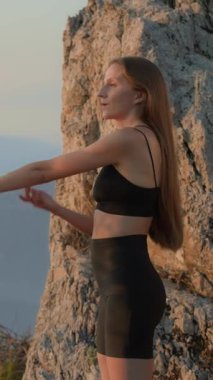 Dikey çekim. Kadın ve vücut geliştirmede omuz germe, kol egzersizleri ve spor kıyafetleri giyerken kas hasarını önleme. Isınma, hareket ve kadın fitness, egzersiz, spor sutyeni reklamlarına başlıyor.