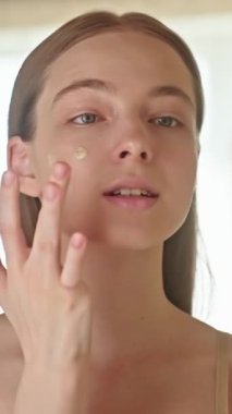 BB, CC kremi, Makyaj Vakfı gibi cilt makyajı hibrit ürünü uygulayan genç bir kadın. Cilt faydalı hafif kaplama nemlendirici, koruyucu, doğal parıltıyı artırıcı.