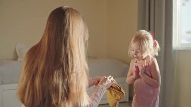Mutlu genç anne, doğum gününde kızını tebrik eder ve ona güzel bir elbise hediye eder. Küçük kız çok şaşırdı ve heyecanlandı. Bağlanma, evde bir aile. Aşk bakımı kavramı