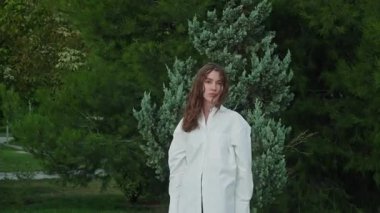 Dışarıdaki kameraya bakarak poz veren manken. Sakin, genç, beyaz bir kızın çarpıcı yüzü. Esmer kadın güzellik portresi. Güzellik videosu konsepti, saç stili, gençlik kültürü, kişisel bakım, özgüven