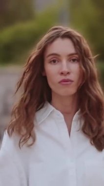 Şehir parkında dalgalı saçlarıyla yürüyen pozitif hayat dolu genç bir kız. Beyaz giysi, şehir sanatı, özgürlük ve gençliği çağrıştırıyor. Moda reklamları, güzellik, kozmetik