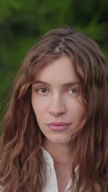 Moda mankeni, güzel esmer kadın kameraya özgüvenle bakıyor, sakin bakıyor, iç huzuru. Cilt bakımı, Güzel yüzlü video konsepti. Genç kızın yakın plan portresi. Özgüven. Gerçek güzellik. 