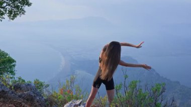 Sakin bir sabahta dışarıda kollarını ve omuzlarını ısıtan formda bir kadın. Hareket kabiliyeti, güç, iyileşme ve doğada aktif bir refah kavramı. Atletik kız dışarıda esniyor. Fiziksel aktivite. 