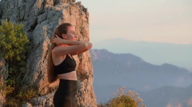 Genç atletik kadın antremandan sonra nefes egzersizi yapıyor. Suset 'te açık havada. Rahatlamış dişi doğada serinliyor. Stres atma, iyileşme, rahatlama ve sağlıklı yaşam tarzı kavramı