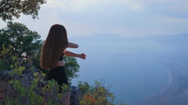 Spor giysili genç bir kadının sabahları ısınma ve dışarıda esneme hareketleri. Fiziksel sağlık, sağlıklı yaşam tarzı ve doğadaki duygusal refah kavramı. Zihinsel Refah.