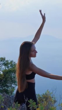 VERTICAL VIDEO Genç kadın Isınma ve kollarını esnetiyor Huzurlu doğal bir ortamda sabah. Açık hava fitness, hareketlilik, farkındalık, sağlıklı yaşam tarzı kavramı. Sağlıklı kadın dışarıda egzersiz yapıyor.