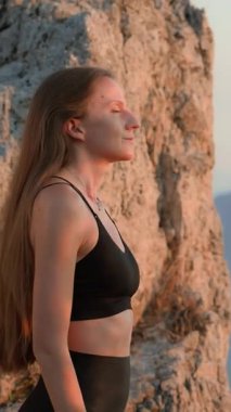 Gün batımında dışarıda idmandan sonra derin nefes almaya çalışan formda bir kadın. Barışçıl bir iyileşme ve doğada rahatlama. Farkındalık, Sağlık, Zihinsel Refah, Sağlıklı Yaşam Tarzı