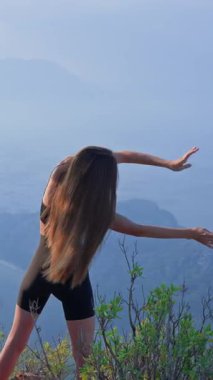 Sessiz bir sabahta kollarını ve omuzlarını ısıtan çok yönlü formda bir kadın. Hareket kabiliyeti, güç ve etkin sağlık kavramı. Atletik kız dışarıda esniyor. Fiziksel aktivite. 