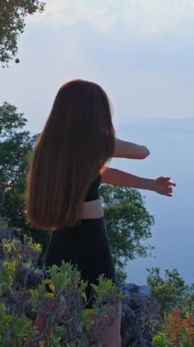 VERTICAL VIDEO Spor giysili genç bir kadının sabah ısınma ve dışarı esneme görüntüsü. Fiziksel sağlık, sağlıklı yaşam tarzı ve ruhsal refah kavramı.. 