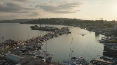Yatı olan hareketli bir Türk marinası gün batımında parlayarak, lüks kıyı turizmi ve sakin bir yat arkaplanından kaçma eğilimini yansıtıyor. Sinop, Türkiye. Türk kültürü. Seyahat turu