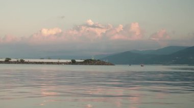 Türkiye 'de gün batımında deniz feneri ve teknelerin bulunduğu sakin bir deniz arka planı, seyahat esin kaynağı için sakin kıyı arkaplanlarını yansıtıyor. Hindi, Gerze. Türk kültürü. Karadeniz 