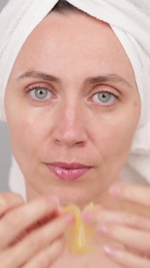 Dikey ekran: Göz bantları ve güzellik kadını kozmetik reklamları için stüdyoda. Uygulamadan sonra ışıltı etkisi. Yüz bakımı ve kolajen parlaklık. Spa, estetik ve detoks. Portre sakin beyaz kadın.