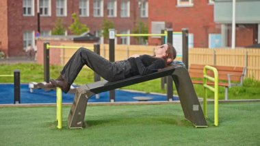 Şehir parkındaki bankta uzanmış gökyüzüne bakan genç bir kadın. Huzurlu ve içsel bir an. Kentsel dinlenme, farkındalık, yavaş yaşam ve zihinsel berraklık kavramı.