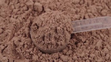 Çikolata protein tozuyla dolu kepçe. Spor besin takviyesi, sağlıklı beslenme, kas gelişimleri ve vücut geliştirme konsepti. Beyaz yağlı protein. Vücut geliştirme spor salonu yaşam tarzı